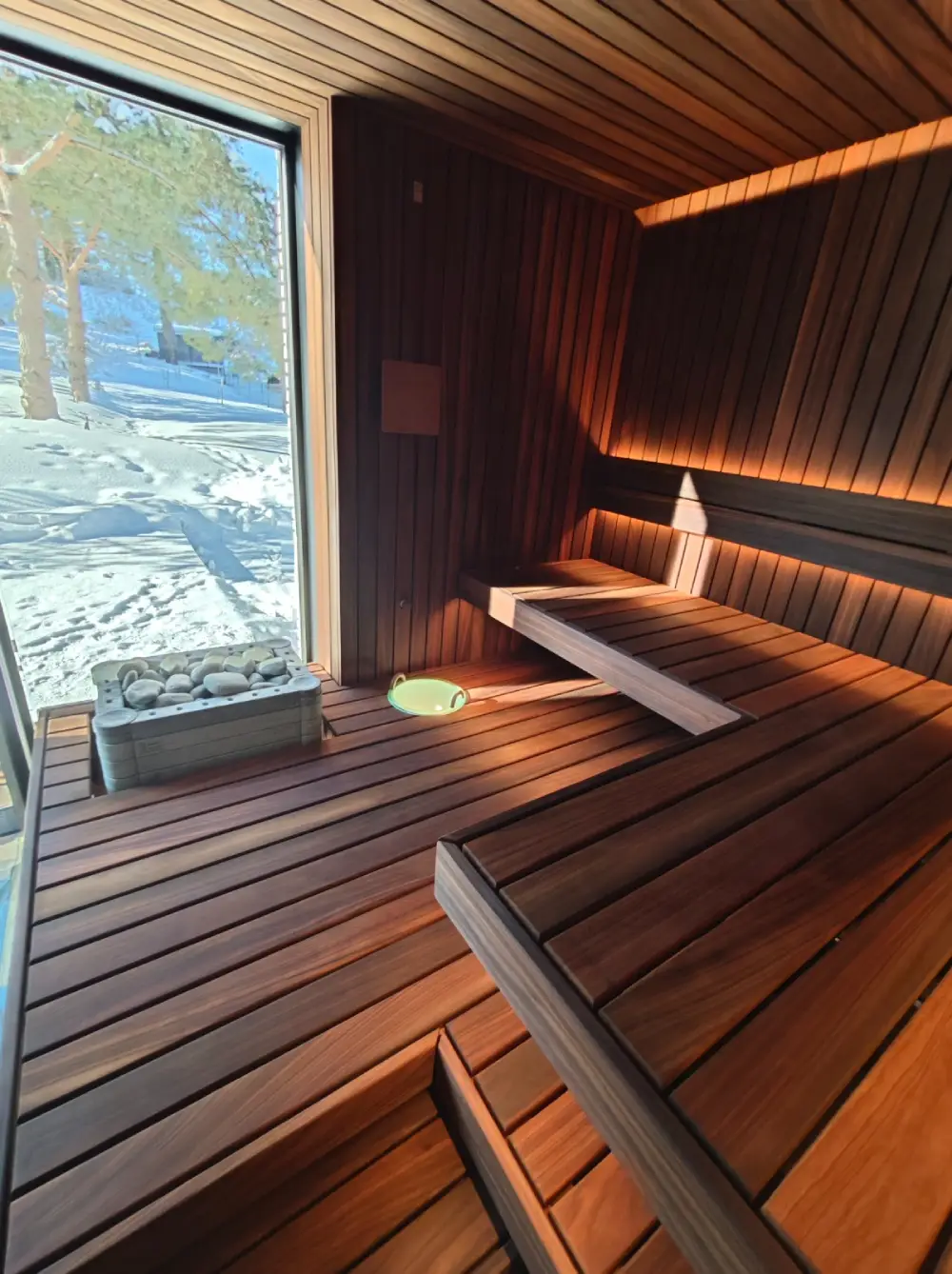 Thermo Abachi sauna cladding beside a window, with benches and a heater.